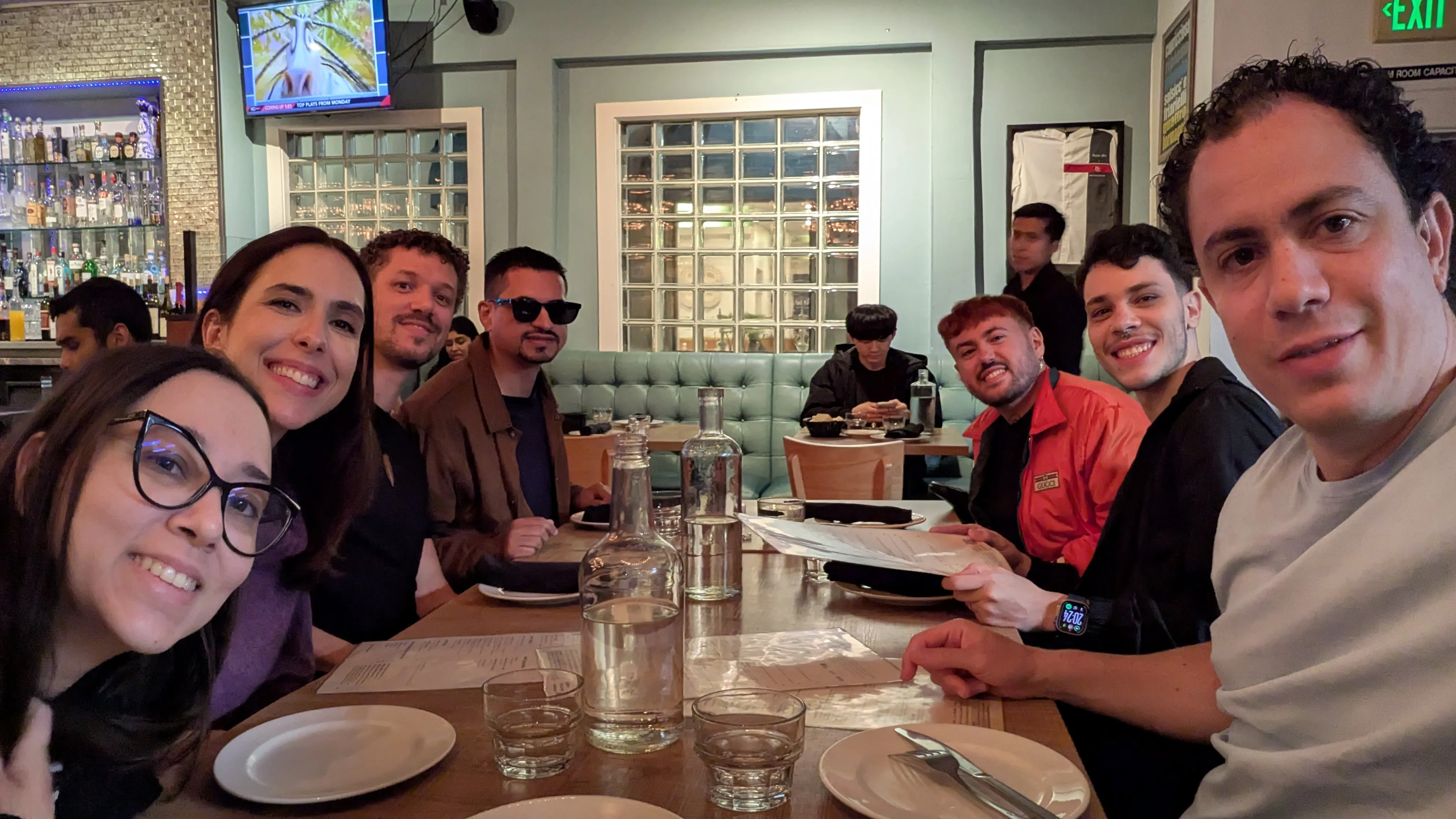 pessoas reunidas para um jantar casual em um restaurante, posando felizes para uma foto em grupo